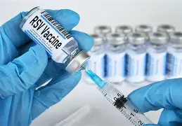A clean, clinical setting with vials of vaccines and a syringe representing vaccination guides